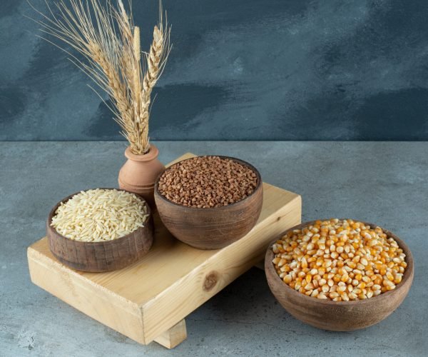 Corn seeds, buckwheat and rice in wooden cups. High quality photo
